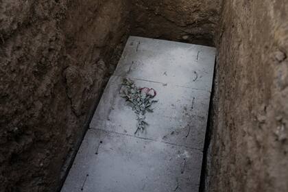 Una losa de concreto cubre el ataúd que contiene los restos del camarógrafo Mario Bucana, que posiblemente murió por el nuevo coronavirus, en el cementerio de Camp Fe en Lima