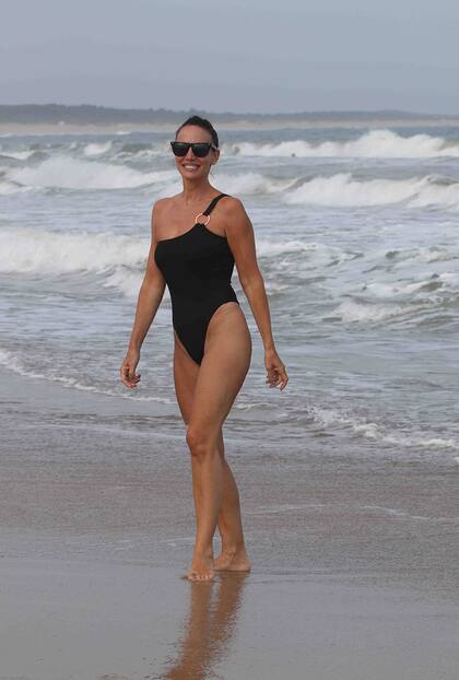 Mientras los chicos hacen deporte, Carolina Prat disfruta de un baño de mar. La modelo eligió un traje de baño enterizo de un solo hombro para lucir su esbelta figura. 