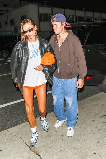 Mientras que el cantante canadiense vistió jeans anchos y un buzo con cierre en color marrón, la modelo combinó un short deportivo naranja con una remera informal y una campera de cuero negra. La gorrita y las gafas de sol, infaltables