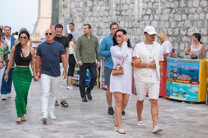 Mientras que la pareja Perry-Bloom vistió looks engamados en Off White, Jeff Bezos y su mujer, Lauren Sanchez, apostaron por el color; él con una remera azul y ella con una falda verde ajustada