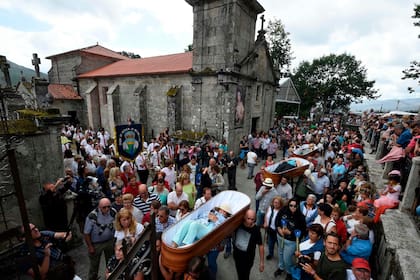Mientras se hace el desfile, los presentes rezan y cantan oraciones católicas