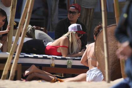 Mientras sus hijos juegan en la orilla, Wanda aprovecha para tomar sol y chequear su celular