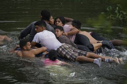 Migrantes cruzan el Río Bravo en un colchón inflable hacia Estados Unidos desde Matamoros, México. (AP Photo/Fernando Llano)
