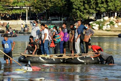Migrantes cruzan el río Suchiate en una balsa desde Guatemala a Ciudad Hidalgo, México