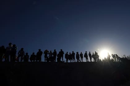Migrantes en el lado mexicano de la frontera EEUU-México, a orillas del Río Bravo, en Ciudad Juárez, México, el 29 de marzo de 2023. (Foto AP/Fernando Llano)
