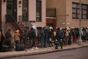 Migrantes esperan en el frío para encontrar refugio fuera del centro de asistencia en la escuela primaria St. Brigid, el 5 de diciembre de 2023, en Nueva York