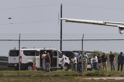 Migrantes esposados suben a una camioneta después de bajar de un avión en el Aeropuerto Internacional Valley, el 31 de agosto de 2025, en Harlingen, Texas, en un operativo de deportación.