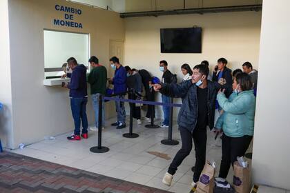 Migrantes guatemaltecos esperan para cambiar dinero tras ser deportados desde Estados Unidos, en el aeropuerto de La Aurora en Ciudad de Guatemala, el lunes 27 de enero de 2025