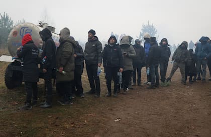 Migrantes hacen cola para tomar agua en la frontera de Belarús y Polonia