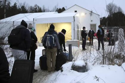 Migrantes hacen fila en un centro de recepción para cruzar de forma irregular desde Champlain, Nueva York, hacia Saint-Bernard-de-Lacolle, provincia de Québec, Canadá