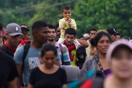 Migrantes, muchos de Centroamérica y Venezuela, caminan por la carretera Huehuetán en el estado de Chiapas, México