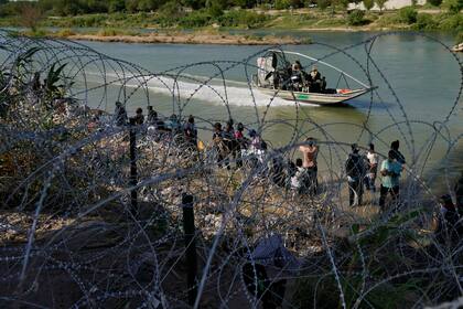 Migrantes que cruzaron a Estados Unidos desde México se encuentran con alambre de púas en la orilla del río Grande, el 21 de septiembre de 2023, en Eagle , Texas. (Foto AP/Eric Gay, Archivo)
