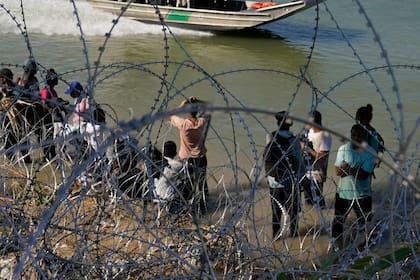 Migrantes que cruzaron a Estados Unidos desde México se encuentran con alambre de púas en la orilla del río Grande, el 21 de septiembre de 2023, en Eagle Pass, Texas (Foto AP/Eric Gay, Archivo)