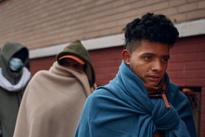Migrantes recién llegados a Nueva York aguardan a las puertas de un albergue, en noviembre de 2023