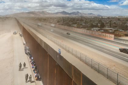 Migrantes se agrupan junto a la valla fronteriza en El Paso, Texas. El 25 de marzo de 2024