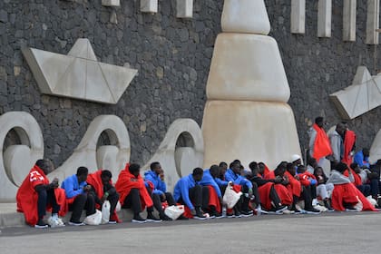 Migrantes sentados en el muelle de La Restinga, en la isla de El Hierro, España