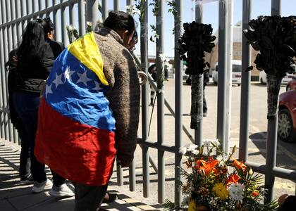 Migrantes venezolanos colocan una ofrenda floral durante una protesta frente a un centro de detención de inmigrantes en Ciudad Juárez, estado de Chihuahua, México, el 28 de marzo de 2023.