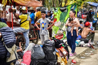 Migrantes venezolanos esperan subir a un barco en el puerto colombiano de Necolí