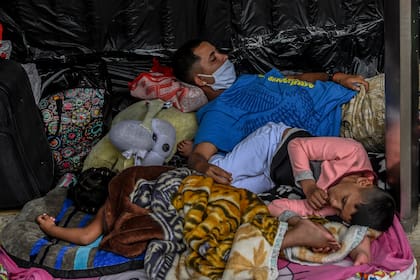 Migrantes venezolanos que desean regresar a su país debido a la pandemia del coronavirus, acampan frente a la terminal de autobuses en Medellín, Colombia, el 19 de mayo de 2020