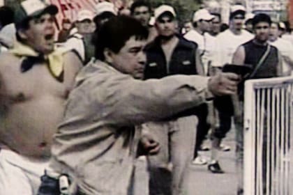 Miguel "Madonna" Quiroz dispara un arma durante los incidentes en el traslado de los restos de Perón a San Vicente, en el año 2006