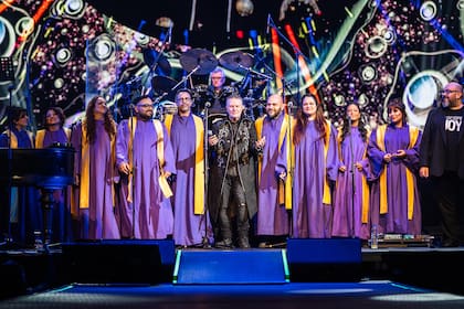 Miguel Mateos y el coro gospel Joy, en el Movistar Arena, durante una poderosa versión -"litúrgica", al decir del vocalista- de "Mundo feliz"