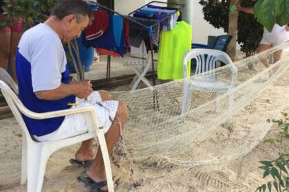 Miguel Salazar repara su atarraya con paciencia a la espera de poder volver a salir a faenar