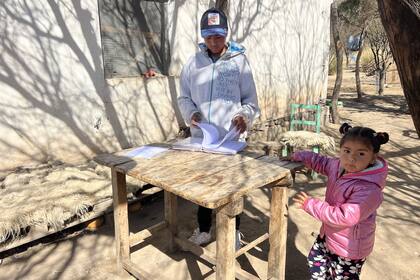 Miguel se sienta a la sombra a hacer la tarea y mostrar sus carpetas del colegio. "Quiero aprender más", dice.