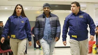 Mike Tyson. escoltado por dos oficiales de policía en el aeropuerto de Santiago, Chile. El ex campeón de los pesados tampoco pudo entrar en nuestro país