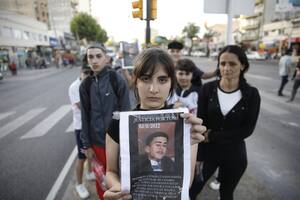 Milagros, con el cartel en el que pide Justicia para Tomás, que la salvó de un robo, pero fue asesinado, en Wilde