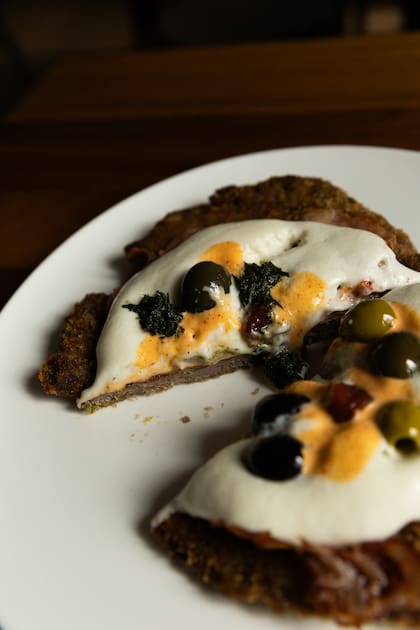 Milanesa con espuma de provolone, olivas marinadas y tomates