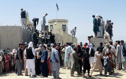 Miles de afganos intentan acceder al aeropuerto internacional Hamid Karzai mientras intentan huir de la capital afgana