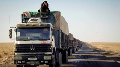 Un hombre se sienta encima de su camión para obtener una mejor señal para hacer una llamada telefónica a Khangobd Soum cerca de la frontera con China en el desierto de Gobi