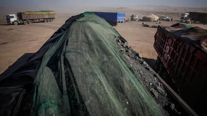 Camiones llenos de carbón esperan a lo largo de la carretera en Tsagaan Khad, a unos 20 kilómetros de la frontera con China en Khanbogd Soum