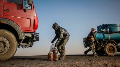 Un hombre lleva botellas con combustible en la carretera cerca de la frontera con China