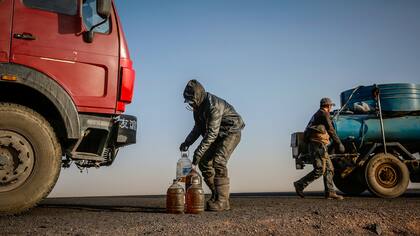 Un hombre lleva botellas con combustible en la carretera cerca de la frontera con China 