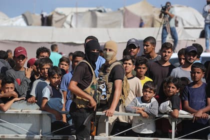 Militantes de Hamas controlan la entrega de rehenes israelíes a la Cruz Roja frente a una multitud de civiles en Gaza