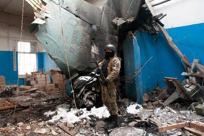 Militar ucraniano junto a la cola vertical de un bombardero ruso Su-34 en un edificio dañado en Kharkiv, Ucrania