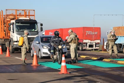 Militares controlando a conductores de vehículos en puesto de control de aduana en la frontera con Brasil