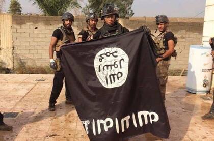 Militares iraquíes sostiene una bandera del Estado Islámico (Archivo) 