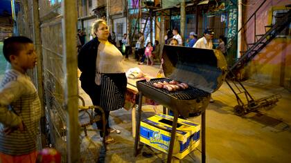 Miriam Cruz, centro, junto a su parrilla donde cocina chorizos