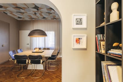 Mobiliario de gran escala y materiales táctiles definen el espacio: una mesa de cemento a medida y sillas Scava de cuero y bronce, con guiños a Mad Men. Lampara colgante en bronce (Másinfinito Casa).