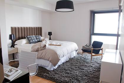 Moderno y con tonos suaves. En este cuarto se jugó con una cabecera de líneas rectas y un género gris aterciopelado