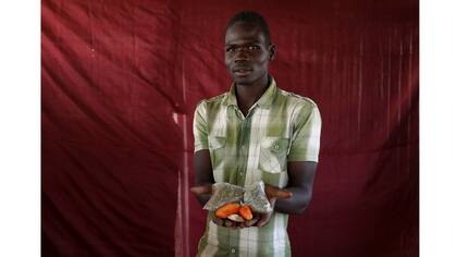 Mohammed Ali sostiene dos tomates y algunas hojas secas de vegetales