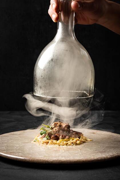 Mollejas de cordero ahumadas sobre humita, tierra de cítrica y papel de remolacha.