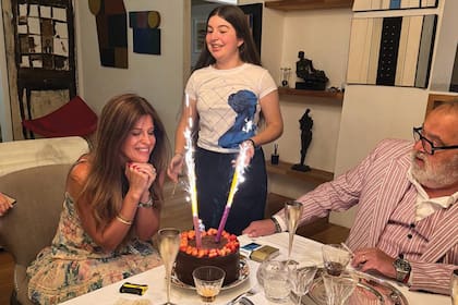 Momento de los deseos frente a la torta de chocolate y ante la atenta mirada de Allegra y Jorge.
