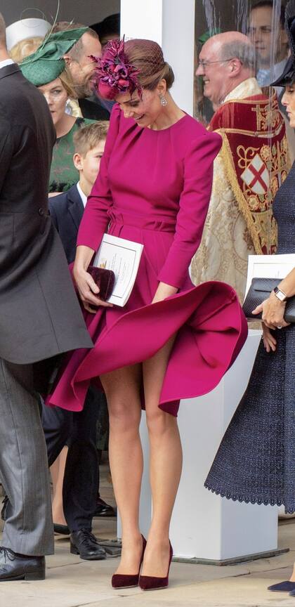 Con humor, la duquesa de Cambridge intenta dominar una vez más, su vestido frente a la ventisca de otoño.