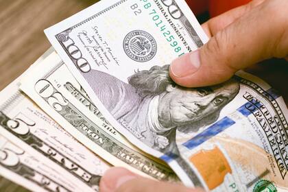 Money, US dollar. A woman counting dollar bills. Close up photo. Concept for economy and personal finance.