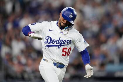 Mookie Betts, de los Dodgers de Los Ángeles, festeja luego de producir una carrera con un sencillo ante los Rojos de Cincinnati, en el segundo juego de la serie de comodines, el miércoles 1 de octubre de 2025 (AP Foto/Mark J. Terrill)