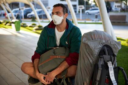 Un pasajero espera en Ezeiza para terminar el viaje: es uno de los repatriados