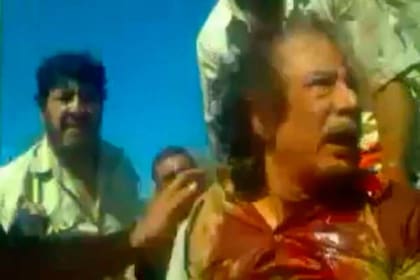 Muammar Khadafy, atrapado por sus enemigos, parece rogar por su vida poco antes de ser ultimado, el 20 de octubre de 2011 en las inmediaciones de Sirte, su ciudad natal (Reuters)
